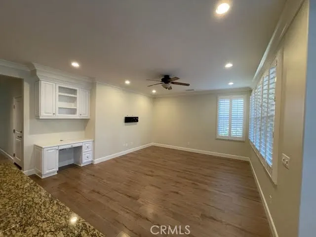 a view of an empty room and a kitchen