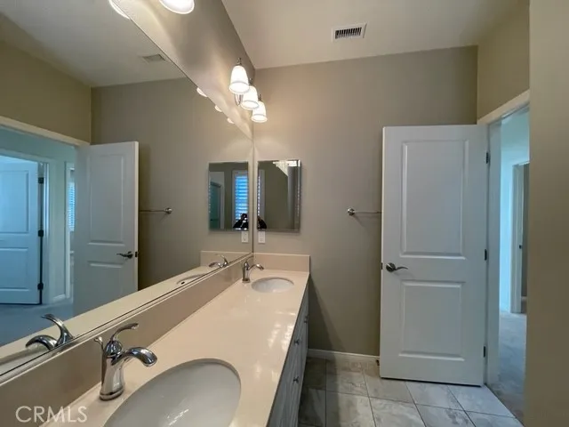 a bathroom with a double vanity sink a mirror and shower