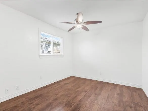 an empty room with a window and ceiling fan