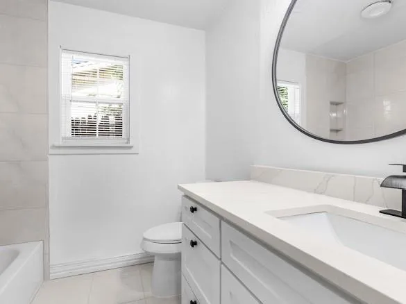 a bathroom with a sink a toilet and a mirror