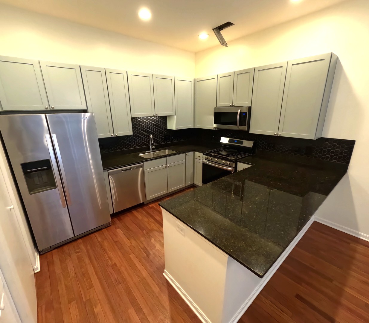 Undisclosed Address Chicago, IL 60610 - Photo 4 of 7 a kitchen with stainless steel appliances a refrigerator a sink a stove white cabinets and wooden floor