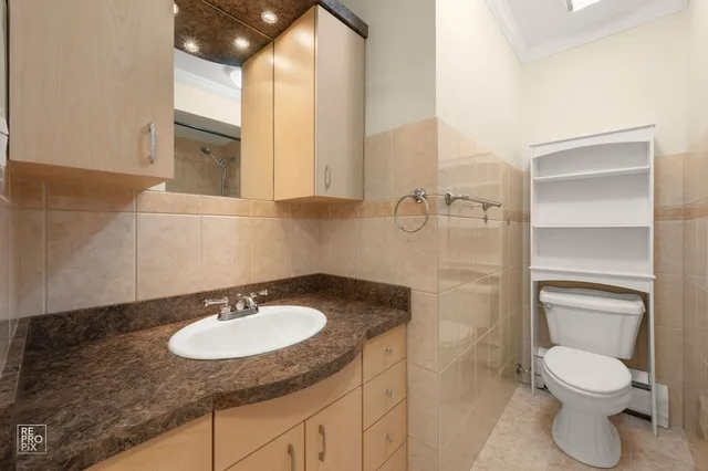 a bathroom with a granite countertop sink toilet and a mirror
