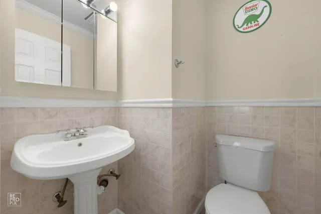 a bathroom with a sink a toilet and a mirror