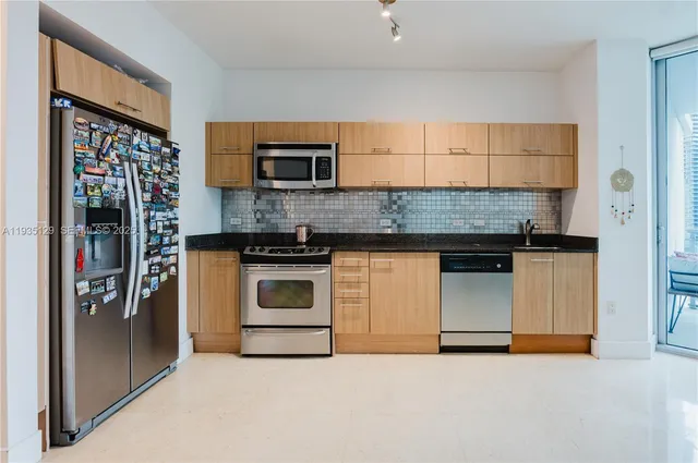a kitchen with stainless steel appliances granite countertop a stove and a refrigerator