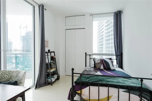 a view of a room that has a bed and a chair in it