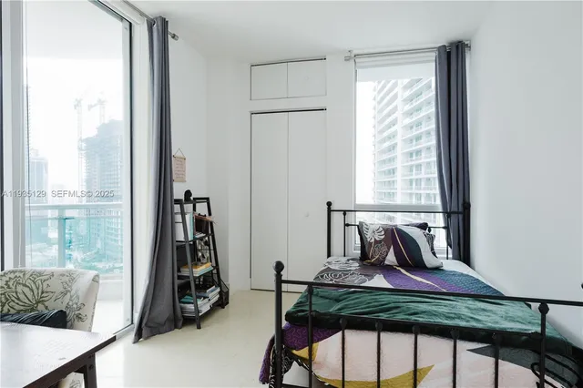 a view of a room that has a bed and a chair in it