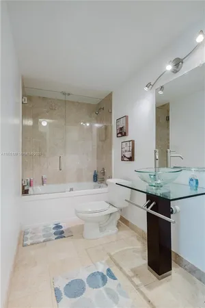 a bathroom with a granite countertop sink a toilet and bathtub