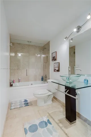 a bathroom with a granite countertop sink a toilet and bathtub