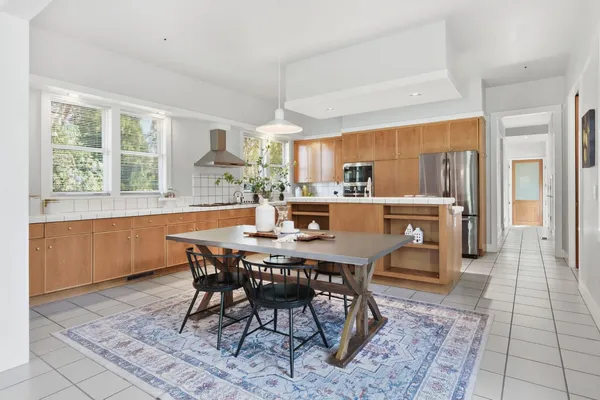 a dining hall with stainless steel appliances a table and chairs