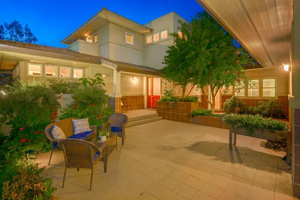 a backyard of a house with table and chairs
