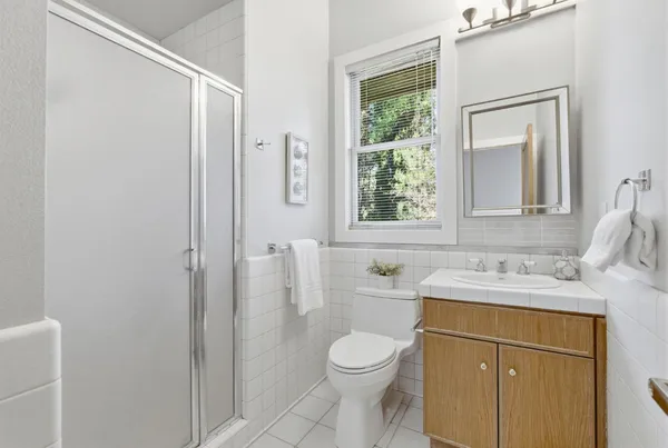 a bathroom with a sink a toilet and shower