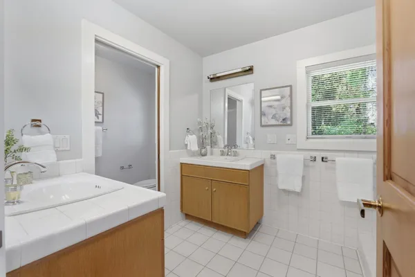 a en suite bathroom with a granite countertop sink and a mirror