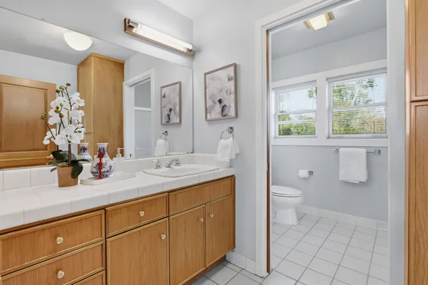 a bathroom with a granite countertop sink toilet and mirror