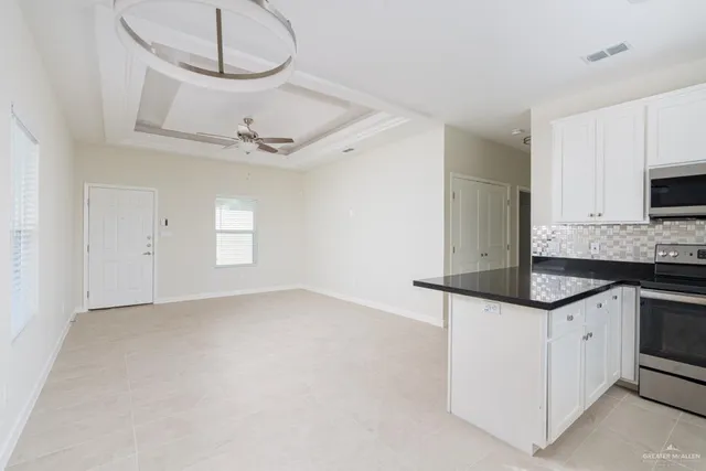 a kitchen with granite countertop a sink a stove and cabinets