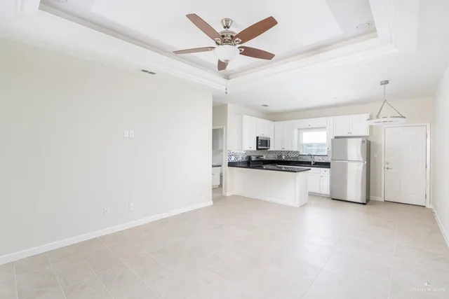 a kitchen with a refrigerator and white cabinets