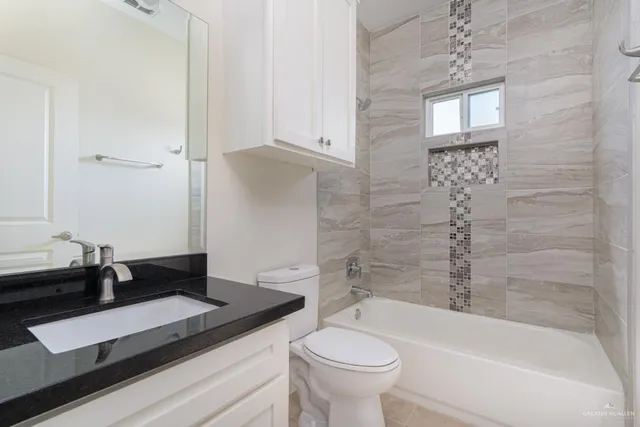 a bathroom with a granite countertop sink toilet and bathtub