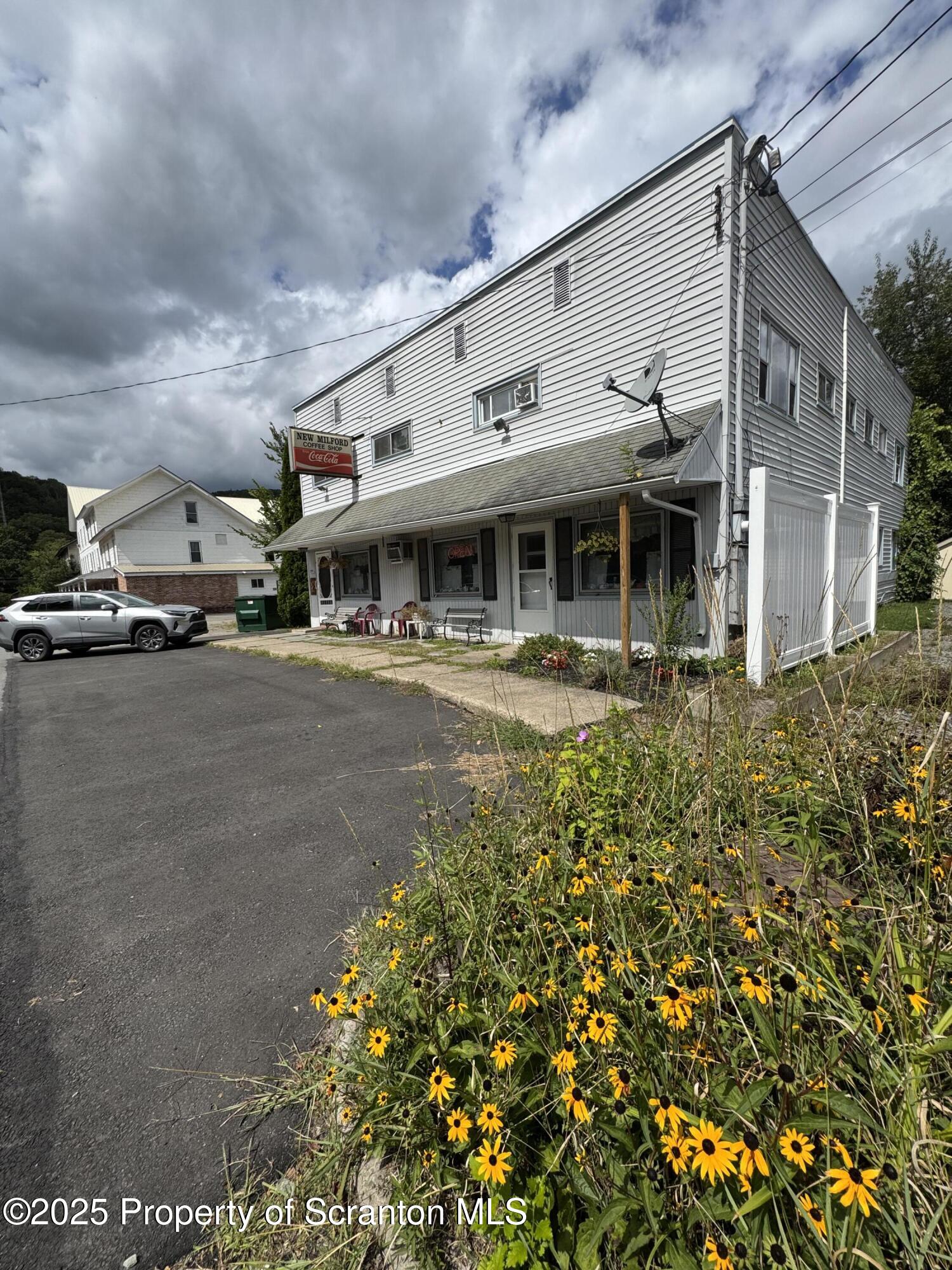 47 Broad Street New Milford, PA 18834 - Photo 18 of 65 a view of large building with a yard and potted plants