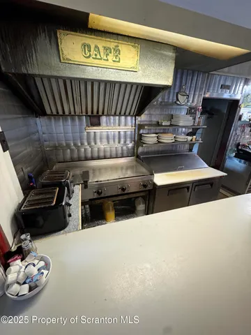 a kitchen with stainless steel appliances a stove a table and chairs