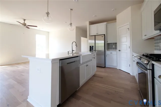 a kitchen with stainless steel appliances kitchen island granite countertop a refrigerator a sink and a stove