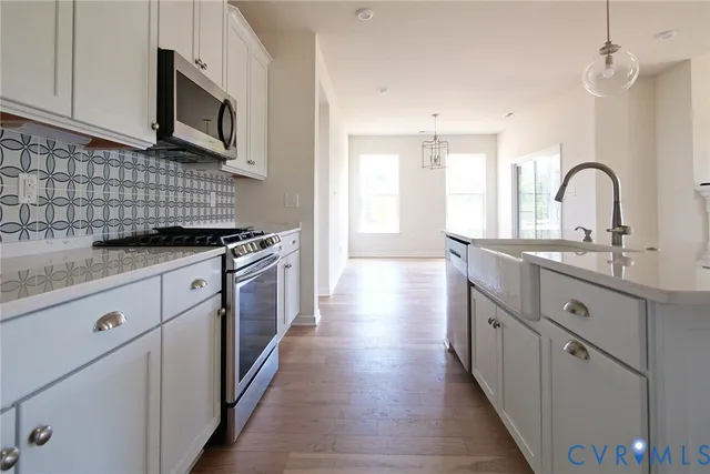 a kitchen with stainless steel appliances granite countertop a sink stove and cabinets