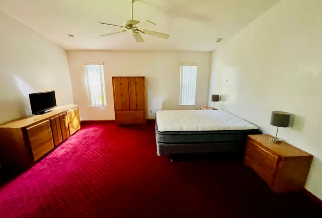 a bedroom with a bed and a flat screen tv