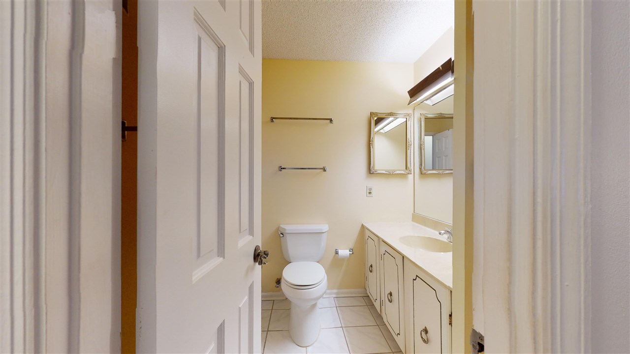 60 Palmer Street St. Augustine, FL 32084 - Photo 16 of 26 a bathroom with a granite countertop toilet a sink and a mirror