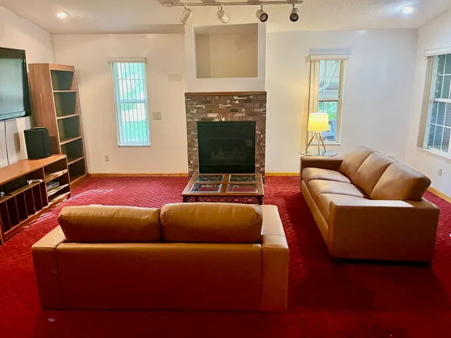a living room with furniture a fireplace and a flat screen tv