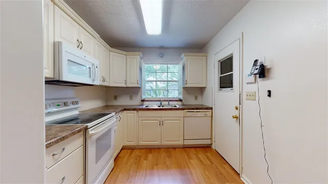 a kitchen with stainless steel appliances granite countertop a sink a stove a refrigerator and cabinets