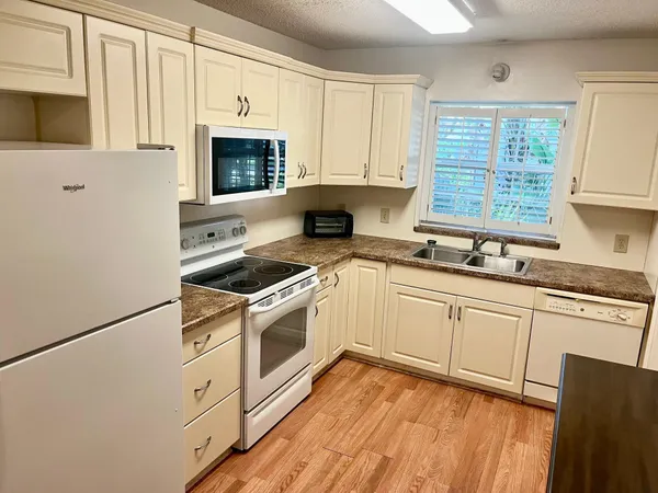 a kitchen with granite countertop a stove a sink and a microwave
