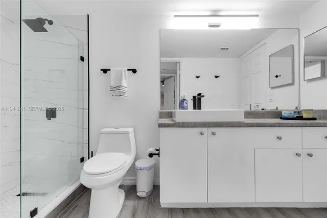 a bathroom with a granite countertop toilet sink and shower