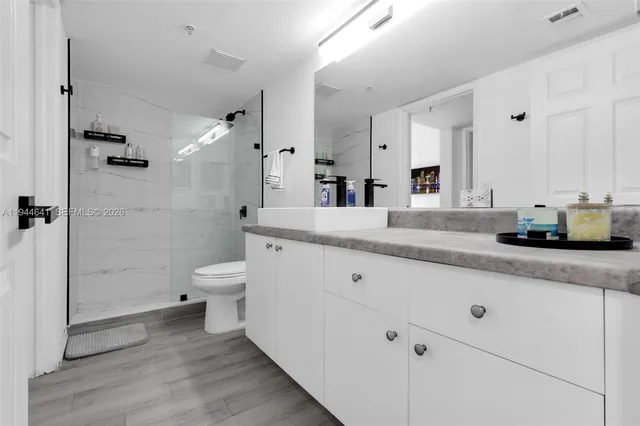 a bathroom with a sink a toilet and shower