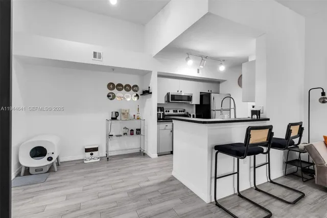 a kitchen with stainless steel appliances kitchen island granite countertop a refrigerator and microwave