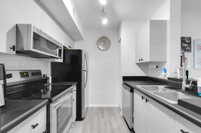 a kitchen with stainless steel appliances granite countertop a sink a stove and a refrigerator