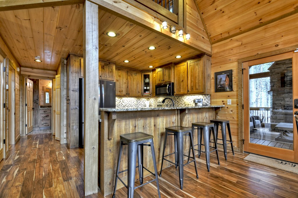 705 George Curtis Road Blue Ridge, GA 30513 - Photo 16 of 49 a kitchen with stainless steel appliances granite countertop a kitchen island wooden cabinets and chairs