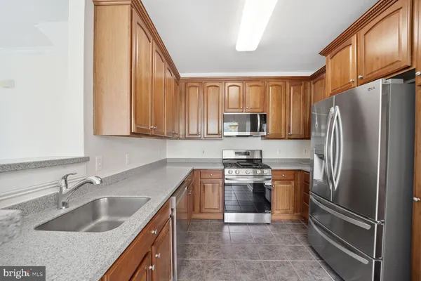 a kitchen with stainless steel appliances granite countertop a refrigerator sink and stove