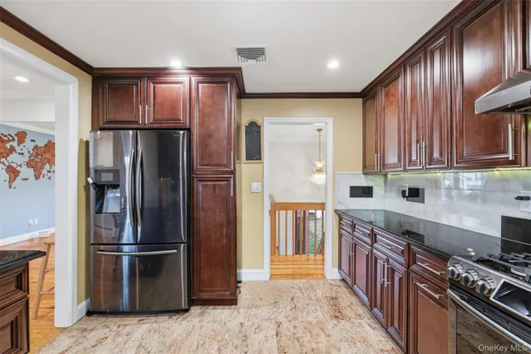 a kitchen with stainless steel appliances granite countertop a refrigerator stove and cabinets