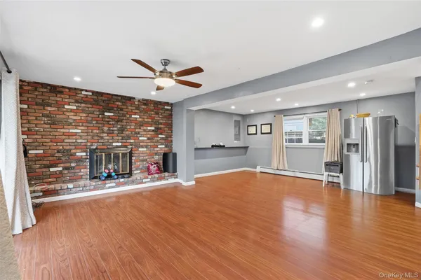 a room with stainless steel appliances wooden floor and a large window