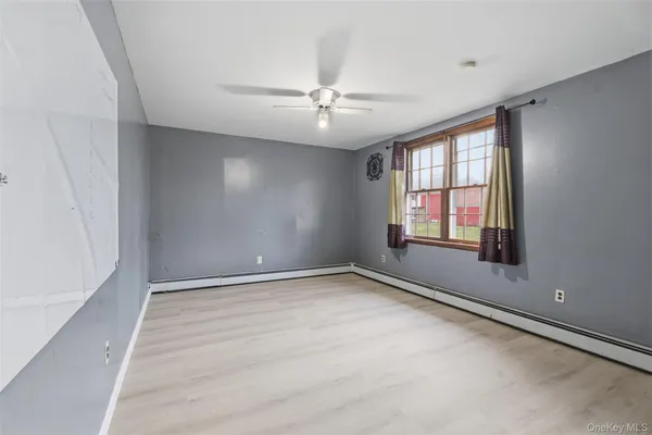 an empty room with windows and ceiling fan