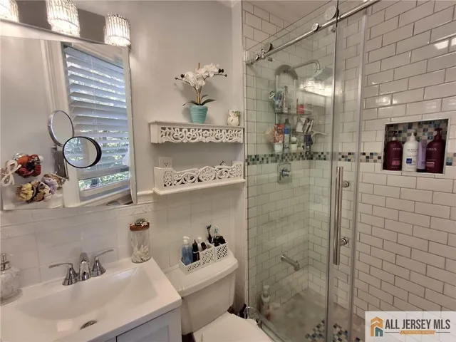 a bathroom with a sink mirror and shower