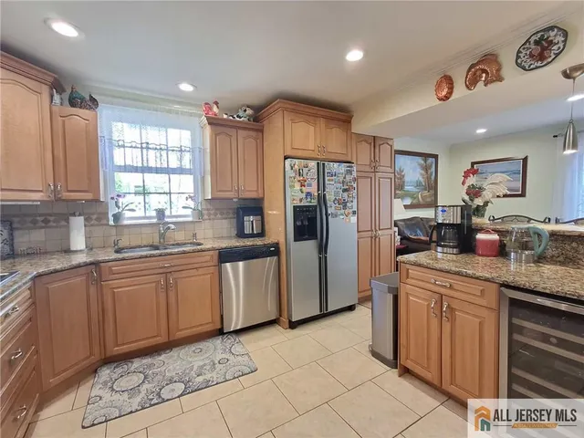 a kitchen with stainless steel appliances granite countertop a refrigerator and a sink