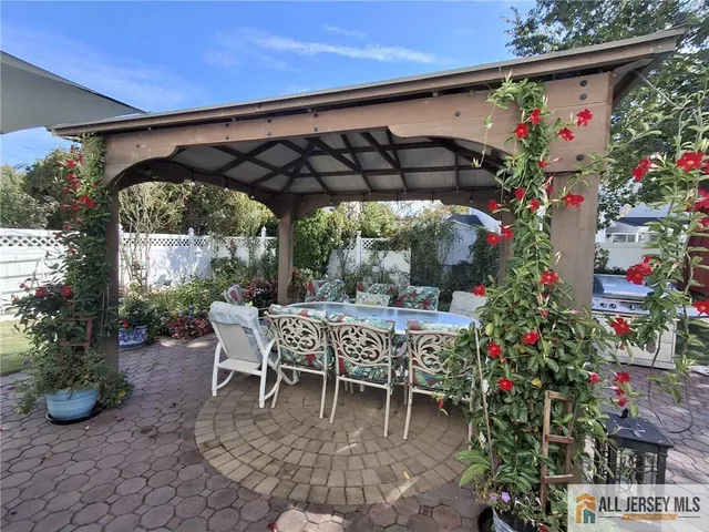 a patio with a table and chairs and potted plants