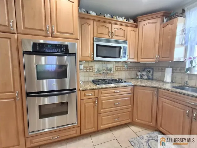 a kitchen with granite countertop white cabinets stainless steel appliances and a sink