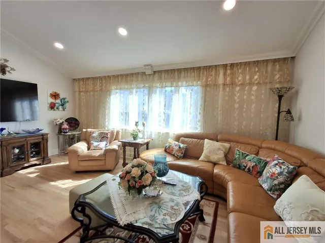 a living room with furniture a flat screen tv and a window