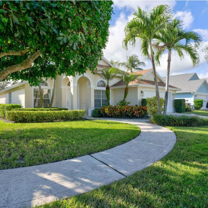 6014 Adams Street Jupiter, FL 33458 - Photo 1 of 15 a front view of a house with garden