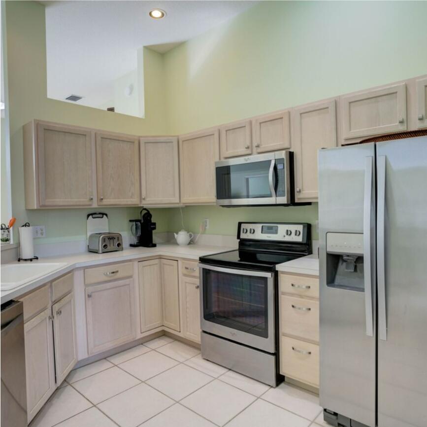 6014 Adams Street Jupiter, FL 33458 - Photo 13 of 15 a kitchen with cabinets stainless steel appliances and a sink