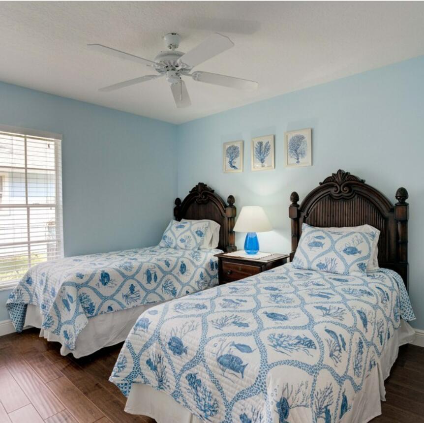 6014 Adams Street Jupiter, FL 33458 - Photo 9 of 15 a bedroom with two beds and a chandelier