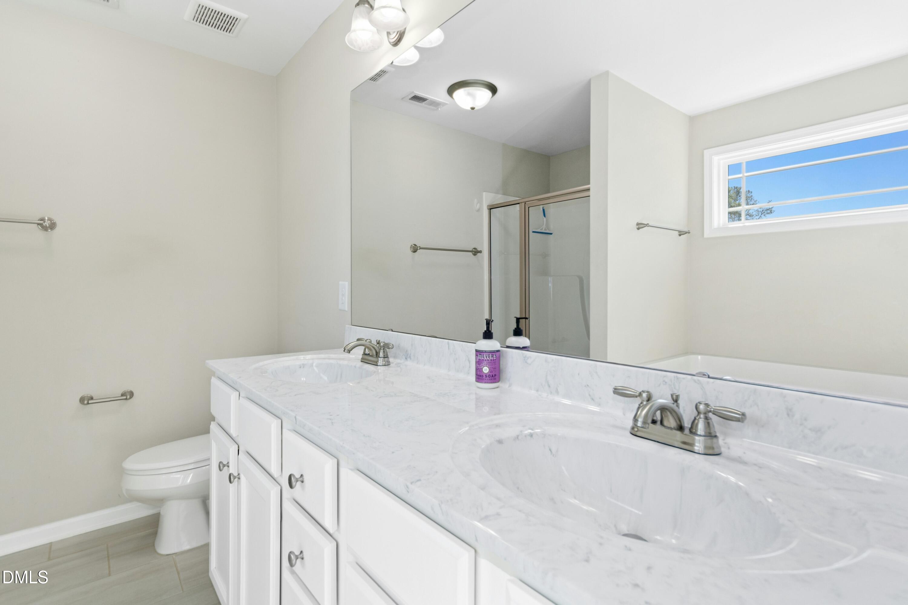 48 Mountain View Drive Garner, NC 27529 - Photo 14 of 29 a bathroom with a granite countertop sink a toilet and a mirror