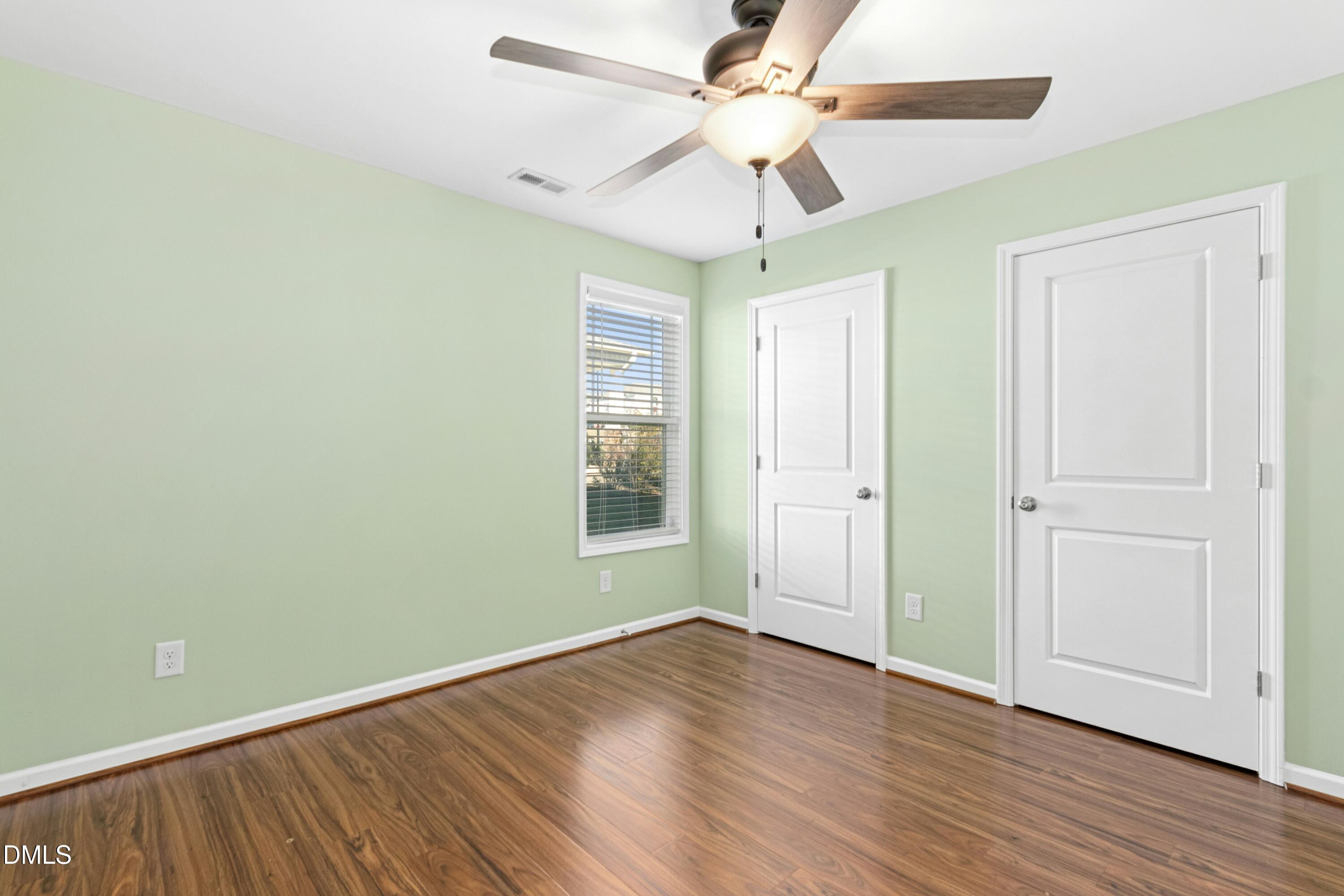 48 Mountain View Drive Garner, NC 27529 - Photo 20 of 29 an empty room with wooden floor ceiling fan and windows