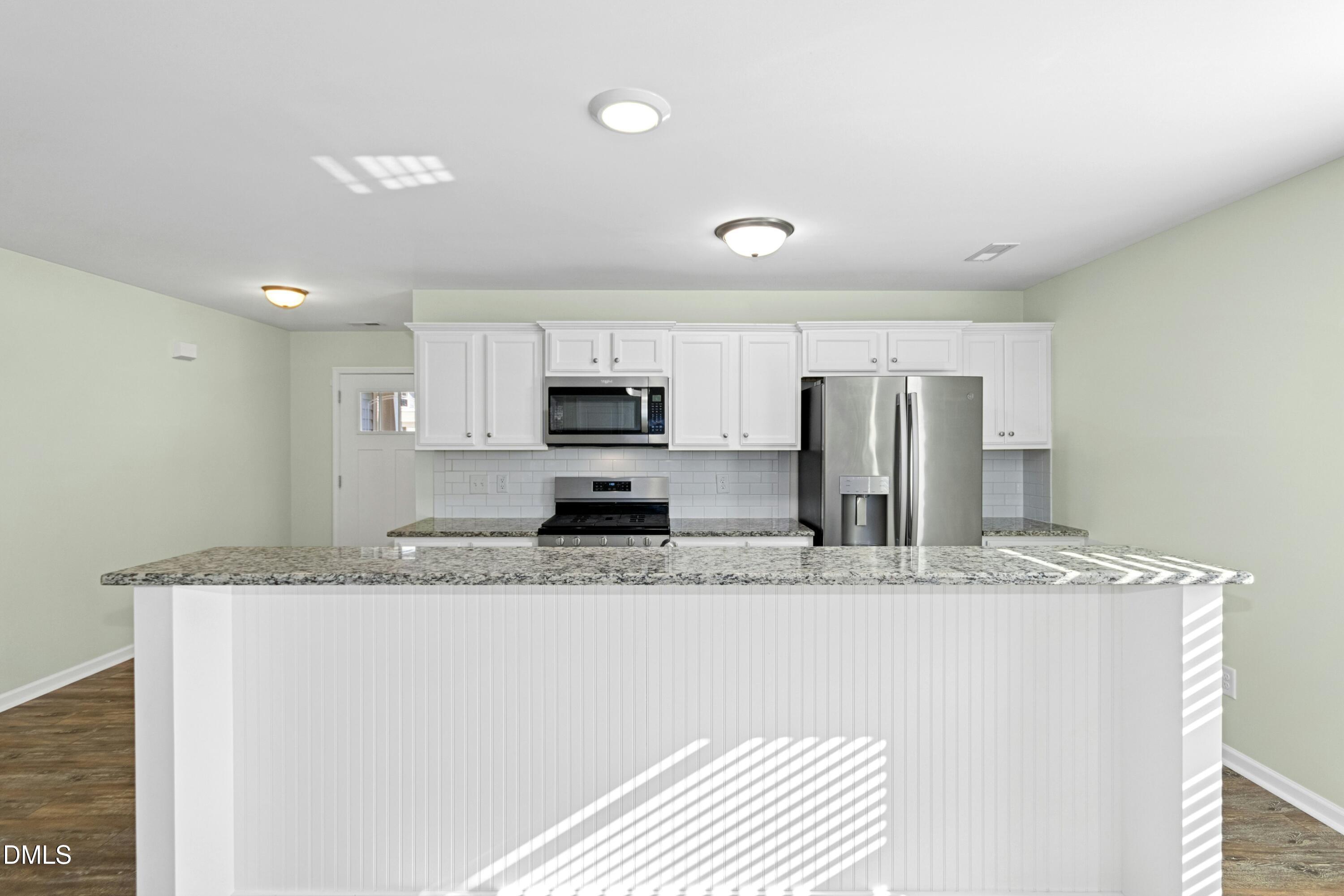 48 Mountain View Drive Garner, NC 27529 - Photo 5 of 29 a large kitchen with granite countertop a sink and white cabinets