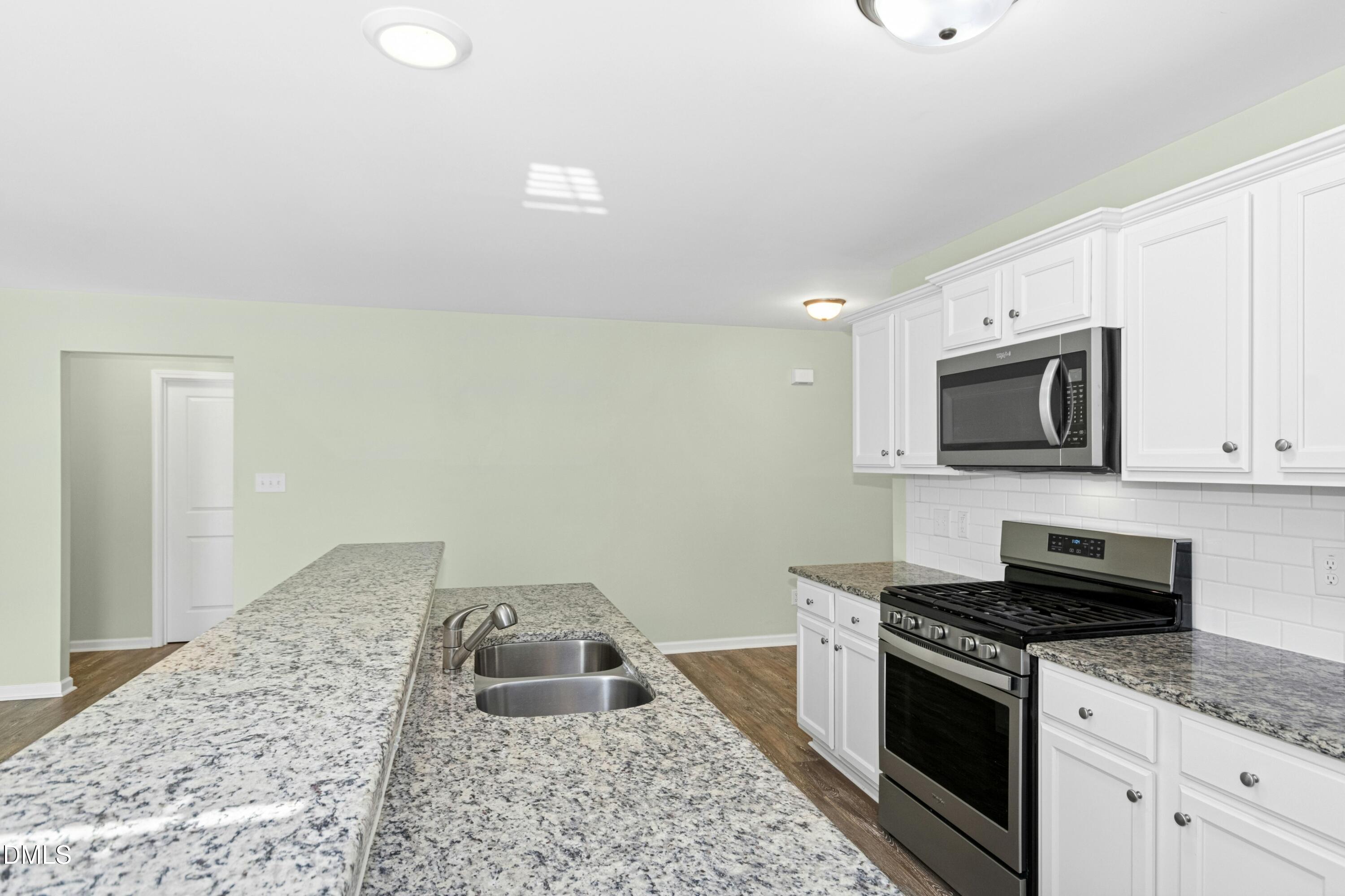 48 Mountain View Drive Garner, NC 27529 - Photo 6 of 29 a kitchen with granite countertop a sink and a stove top oven